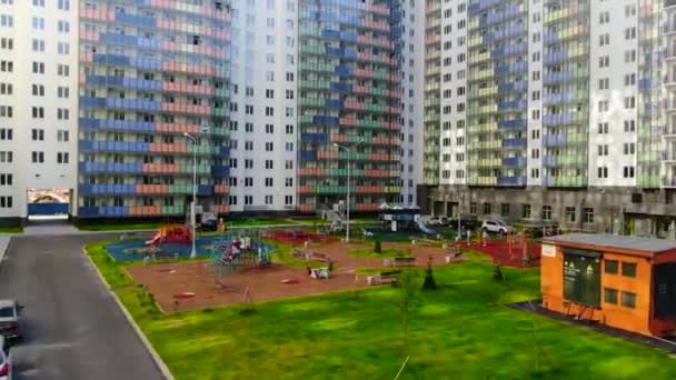 Вид зверху на сучасний ландшафт дитячого майданчика в житловому районі. Рух. Барвистий майданчик з лавками для відпочинку в сучасному житловому районі міста — стокове відео