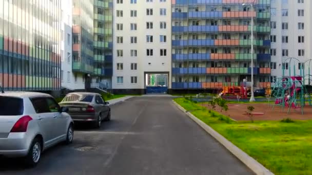 Vista de patio con pasaje en casa. Moción. Pasaje en casa entre patios de complejos residenciales de varios pisos en el soleado día de verano — Vídeo de stock