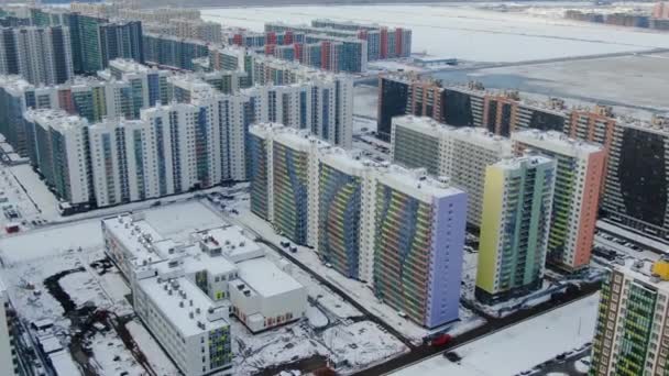 Modern district with multi-storey complexes in winter. Motion. Top view of beautiful landscaped area with residential colorful buildings in winter. Panorama of winter residential area — 비디오