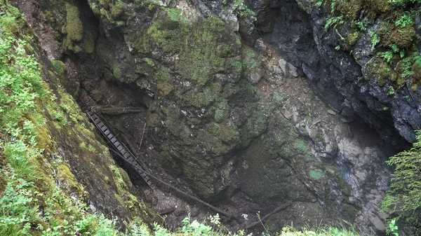 Vista superior da perigosa trilha dentro do desfiladeiro profundo. Imagens de stock. Ar de fundo natural de floresta verde e a ravina . — Fotografia de Stock