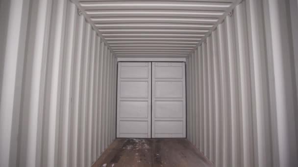 Inside large shipping container. Stock footage. View from inside locked cargo container with white striped iron walls. Empty light and locked cargo trailer container — Stock Video