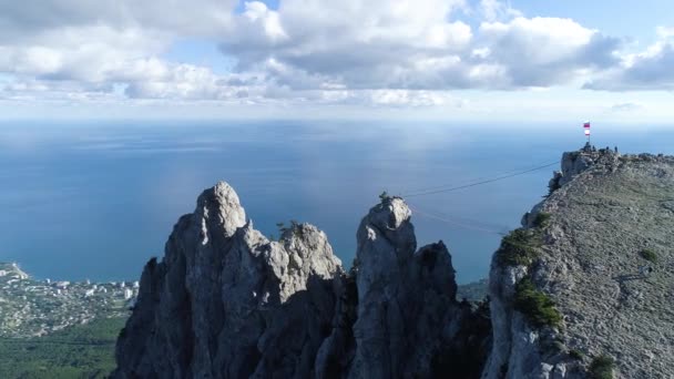 Tourists on the peak of high rocks. Shot. Sport and active life concept. Top view of the tourist climb up the mountain — Stock Video