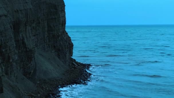 海岸近くの海の空中ビュー。撃たれた海の近くの高い崖の上のビュー。岩の上で荒れ狂う波 — ストック動画