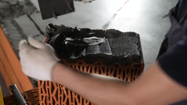 Worker puts cement on a brick on a construction site. Stock footage. Bricklayer laying bricks to make a wall, he is putting grout on top of a brick — 비디오