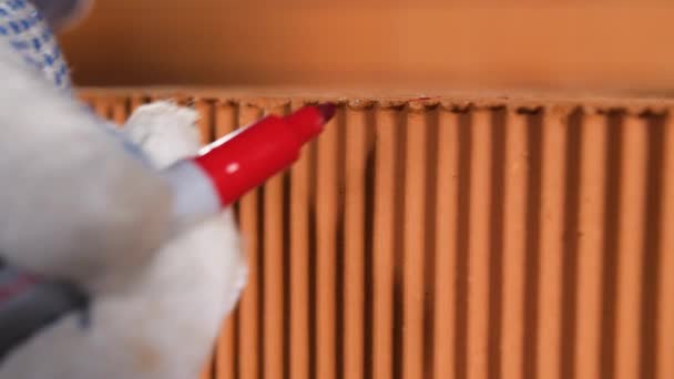 Marques lieu de coupe avec marqueur. Images d'archives. Gros plan du travailleur sur les marques de chantier place pour la coupe avec marqueur rouge sur la brique 