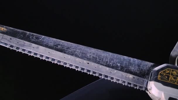Close-up of powerful electric saw blade on black background. Stock footage. Large reciprocating electric saw for professional carpentry — Stock Video