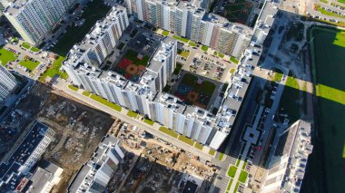 Kompleksi yapım aşamasında olan yüksek binalar. Hareket. Yakın yerleşim ve yerleşim alanının görülebilir karşıtlığının üst görünümü