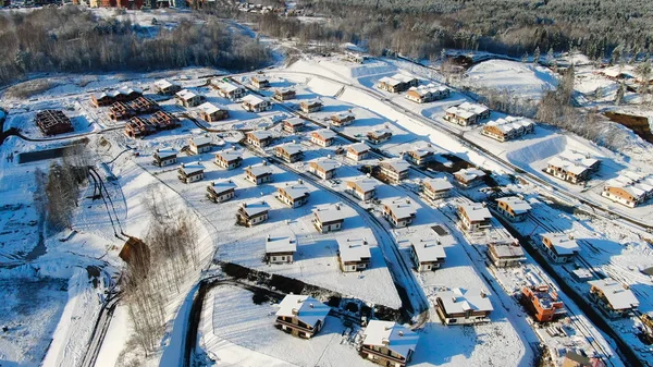 Vista superior de las casas de campo en invierno. Moción. Bosque con vista aérea y casas unifamiliares en invierno — Foto de Stock