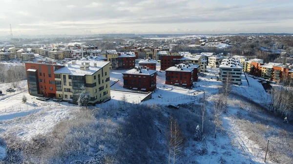 Vue de dessus de la ville en hiver avec neige sur les toits par une journée ensoleillée. Motion. Belle journée ensoleillée en ville en hiver — Photo