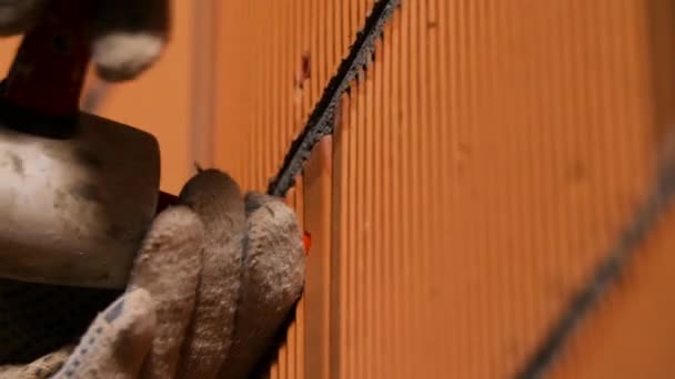 Ο ξυλουργός εισάγει πείρο. Στικ. Κοντινό πλάνο του ανθρώπου με γάντια εισάγοντας πείρο σε τρύπα στον τοίχο από τούβλα. Στοιχεία κατασκευής για συνδετήρες — Αρχείο Βίντεο