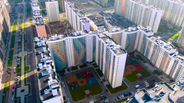 Çok katlı binaların havadan görünüşü, apartman blokları, bahçedeki oyun alanları. Hareket. Yeni renkli evlerin ve yolların üzerinde park etmiş arabalarla uçuyor.. — Stok video