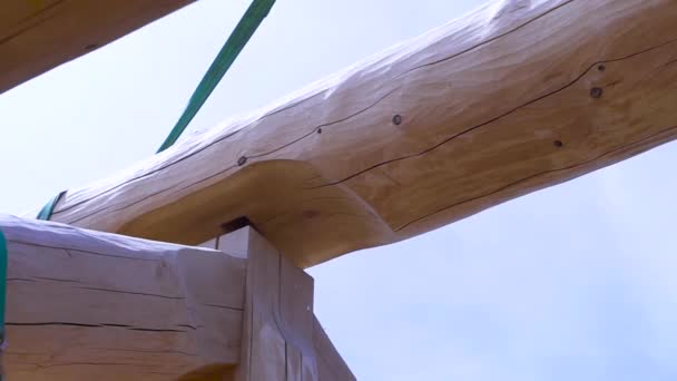 Instalación de vigas de madera en el sitio de construcción, el sistema de armadura de techo de la casa. Clip. Techo de la casa incompleta sobre fondo azul cielo nublado . — Vídeos de Stock