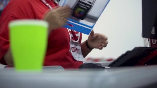 Primer plano de la mujer cajero en el trabajo durante el escaneo de códigos de barras de bienes. Clip. Comprar diferentes productos en el supermercado . — Vídeos de Stock