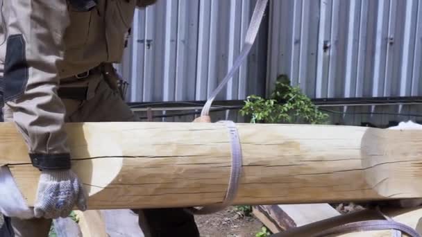 Constructeur au travail avec la construction à ossature de maison en bois à l'extérieur en été. Clip. Charpentier essayant de soulever la bûche à l'aide d'une grue . — Video