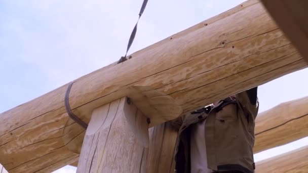 Bauindustriekonzept, Ansicht eines Zimmermanns, der versucht, die Kabelkonstruktion abzuhängen. Clip. der Prozess der Montage des Holzdaches eines neuen Gebäudes. — Stockvideo