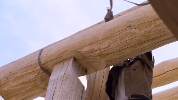 Concepto de la industria de la construcción, vista inferior de un carpintero tratando de desenganchar la construcción del cable. Clip. El proceso de instalación de techo de madera de un nuevo edificio . — Vídeos de Stock