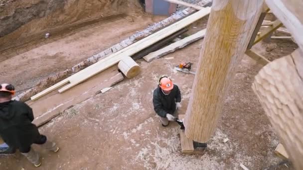 Top view of a male carpenter loosening the jack tension to support wooden wall element at the construction site. Clip. Unfinished wooden building, working outdoors. — Stock Footage Top view of a male carpenter loosening the jack tension to support wooden wall element at the construction site. Clip. Unfinished wooden building, working outdoors. Royalty Free Stock Footage