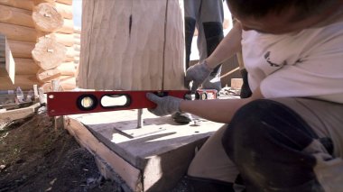 Ahşap işçiliği, eldivenli erkek katılımcı kereste ölçme aletini kullanıyordu. Şarjör. İnşaat alanında profesyonel ekipmanlı bir marangoz..