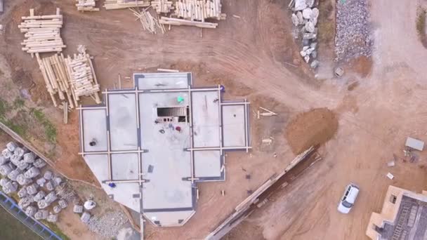 Вид с воздуха на стройплощадку с фундаментом будущего дома. Клип. Вид сверху на сельскую обезьяну, маленькую деревню у бетонного фундамента . — стоковое видео