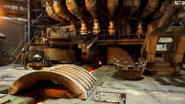 Metalürji fabrikasında kıvılcımlar saçan bir fırının yanında duran çelik işçileri, ağır sanayi konsepti. Stok görüntüleri. Çelik fabrikasının sıcak dükkanının içine bak..