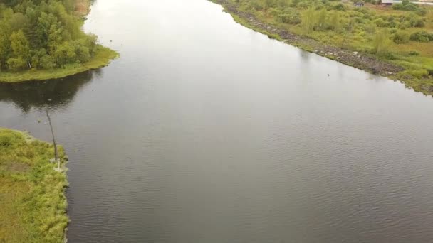 Vista aérea de um rio florestal e campos verdes na primavera. Imagens de stock. Paisagem rural de rio largo rodeado por prados verdes frescos . — Vídeo de Stock