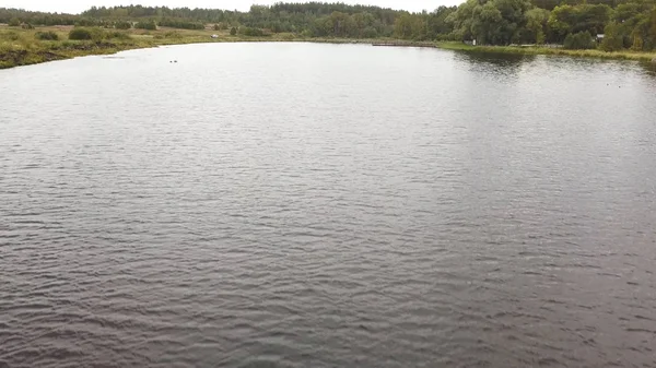 Vue aérienne d'une rivière forestière et de champs verts au printemps. Images d'archives. Paysage rural de grande rivière entouré de prairies verdoyantes fraîches . — Photo