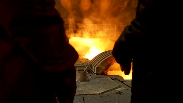 Zadní pohled dvou oceláren na odlévání ingotů stojících před elektrickou obloukovou pecí v horké dílně, hutní výroba. Záběry ze skladu. Koncept těžkého průmyslu. — Stock video