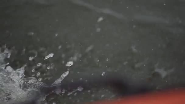Close-up van het water onder drijvende boot. Kunst. Water spatten als boot snijdt door het oppervlak van het meer waarop het drijft. Snelheid van de boot en spetterend water in zee avontuur — Stockvideo