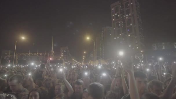 Yekaterinburg, russland-august, 2019: Menschenmassen bei Konzerten leuchten nachts mit Taschenlampen. Kunst. Viele Menschen bei großer Feier in der Stadt stehen beim Konzert und lassen abends Laternen leuchten — Stockvideo