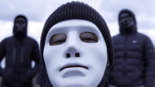 Men in black jackets and masks. Footage. Criminal gang in black plastic masks and leader in white mask on background of cloudy sky. Masked social criminal gang — 스톡 사진