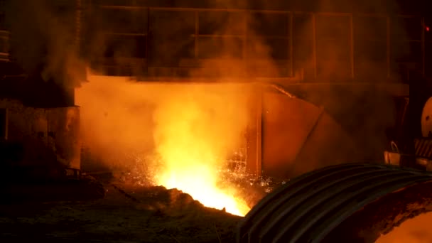 The blast furnace with flowing liquid metal and flying sparkles. Stock footage. Close up of the hot metal production at the factory, heavy industry concept. — 비디오