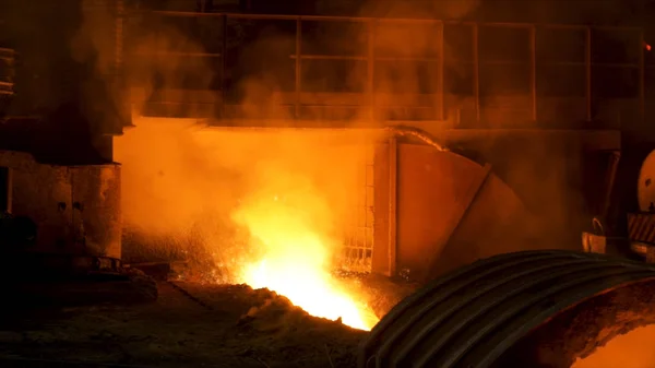 The blast furnace with flowing liquid metal and flying sparkles. Stock footage. Close up of the hot metal production at the factory, heavy industry concept. — 스톡 사진