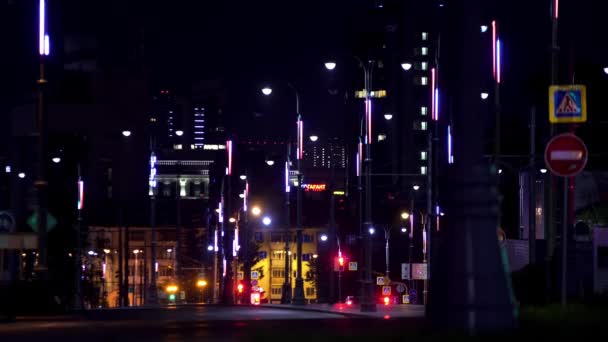 Paisaje nocturno del gran centro de la ciudad con luces brillantes y coches raros en movimiento. Imágenes de archivo. Carretera del distrito central de la ciudad iluminada por farolas . — Vídeo de stock