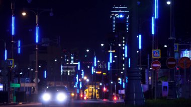 Gece şehrinin caddesi Yekaterinburg, binaların parlak ışıkları ve Visotsky gökdeleni. Stok görüntüleri. Geceleri çok araba sürüyor..