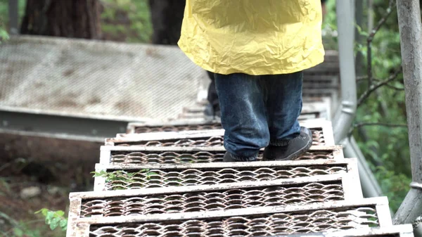 Vista superior de un hombre excursionista bajando las escaleras de metal en el bosque. Imágenes de archivo. Primer plano de las piernas del viajero en el camino en el parque nacional . — Foto de Stock