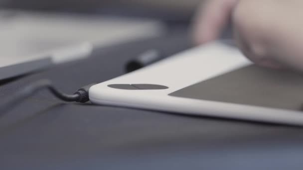 Close up of woman hand using electronic pen while working at modern office with a tablet. Stock footage. Graphic designer working and drawing illustration on tablet. — ストック動画