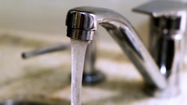 Pouring water from a tap in a kitchen. Concept. Close-up of water pouring from the tap — ストック動画