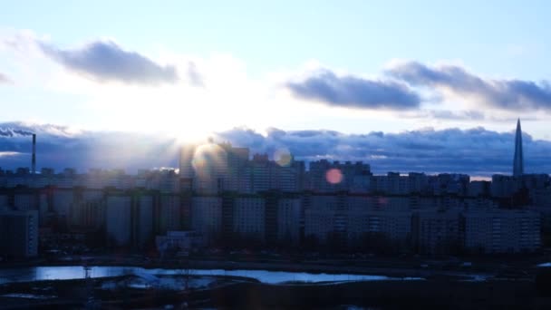 Vista de la ciudad moderna en invierno bajo el sol. Concepto. Hermosa vista del sol sobre la ciudad con una llamarada solar — Vídeos de Stock