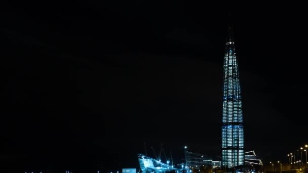 Pohled na mrakodrap pokrytý lucernami v moderním městě v noci. Koncept. Zimní městská krajina moderního mrakodrapu v noci — Stock video