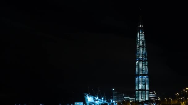 Vista de um arranha-céu coberto de lanternas em uma cidade moderna à noite. Conceito. A paisagem urbana de inverno de um arranha-céu moderno à noite — Vídeo de Stock