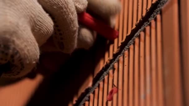 Närbild av människan händer i skyddshandskar som hamrar en plugg i väggen. Lagerbilder. Begreppet reparation och renovering, arbetare och professionella verktyg. — Stockvideo