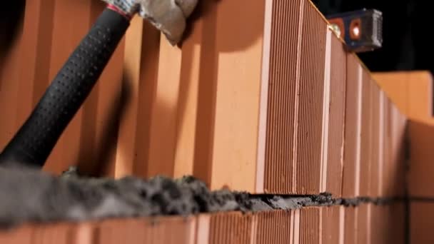 Industrial worker building exterior walls with orange bricks and mortar. Stock footage. Bricklayer putting down another row of bricks. — 비디오