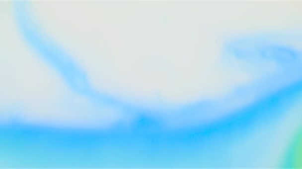 Close-up van iriserende verf op een witte vloeistof. Voorraadbeelden. Blauwe verf op een witte vloeistof wordt prachtig gegoten in patronen — Stockvideo