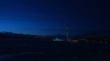 Geceleri modern bir şehirde fenerlerle kaplı bir gökdelenin manzarası. Kavram. Geceleri modern gökdelenlerin kış manzarası