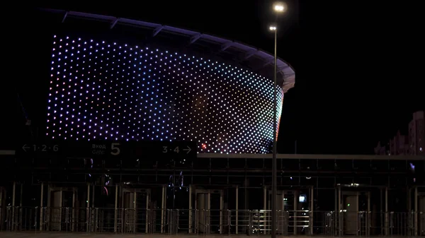 Estádio multiúso com muitas luzes bonitas no fundo do céu noturno. Imagens de stock. Estádio de futebol central moderno com iluminação brilhante e portões de entrada principais . — Fotografia de Stock