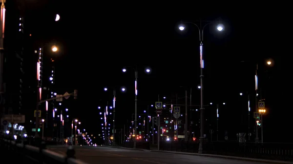 Нічний міський краєвид порожньої дороги освітлений безліччю ліхтарів, романтика літньої нічної концепції. Відеоматеріал. Центр міста пізно ввечері.. — стокове фото