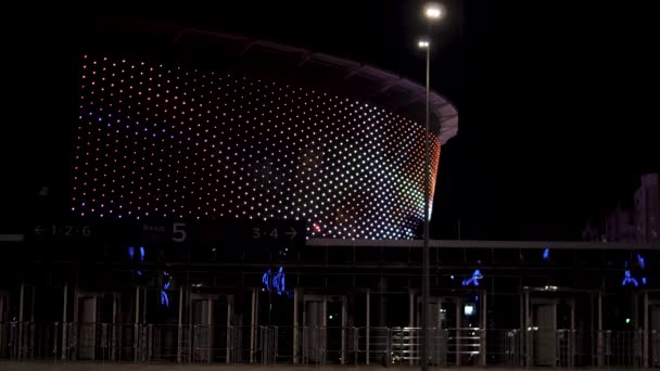 Estádio multiúso com muitas luzes bonitas no fundo do céu noturno. Imagens de stock. Estádio de futebol central moderno com iluminação brilhante e portões de entrada principais . — Vídeo de Stock