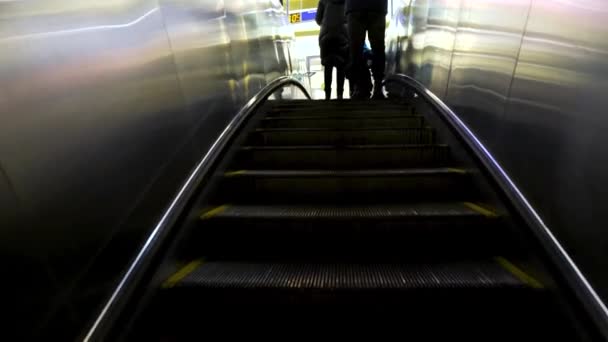 Subiendo las escaleras mecánicas de metal desde la estación de metro, transporte público. Concepto. Vista trasera de un hombre, una mujer y un niño tomando escaleras mecánicas en el metro . — Vídeos de Stock