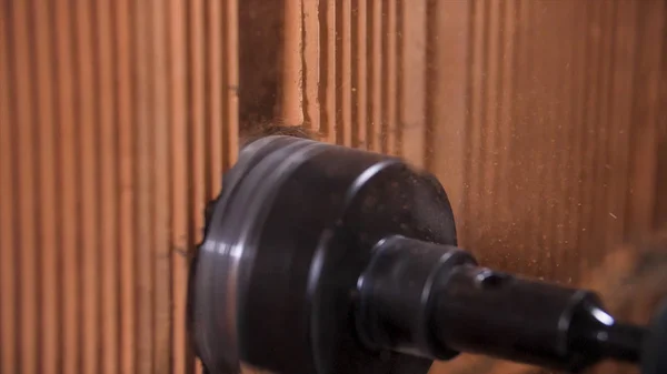 Close up of rotary hammer drilling a hole for outlets in red brick wall. Stock footage. Proffessional equipment at the construction site.