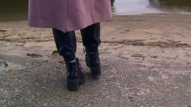 Woman walking by water under bridges. Stock footage. Rear view of attractive young woman walking under old bridges in autumn — 비디오